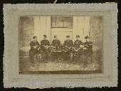 Six soldats assis autour d'une table en train de boire